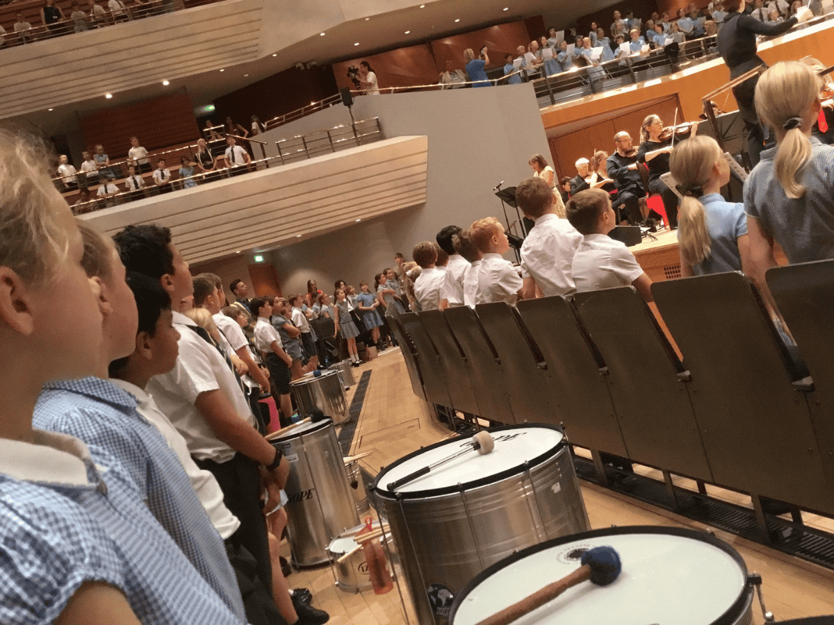 Year 4 pupils from Gorsey Bank sit in the Bridgewater Hall with their drums ready to play alongside the Halle orchestra