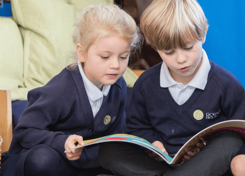 Image of infant Gorsey Bank pupils (boy and girl) reading together.