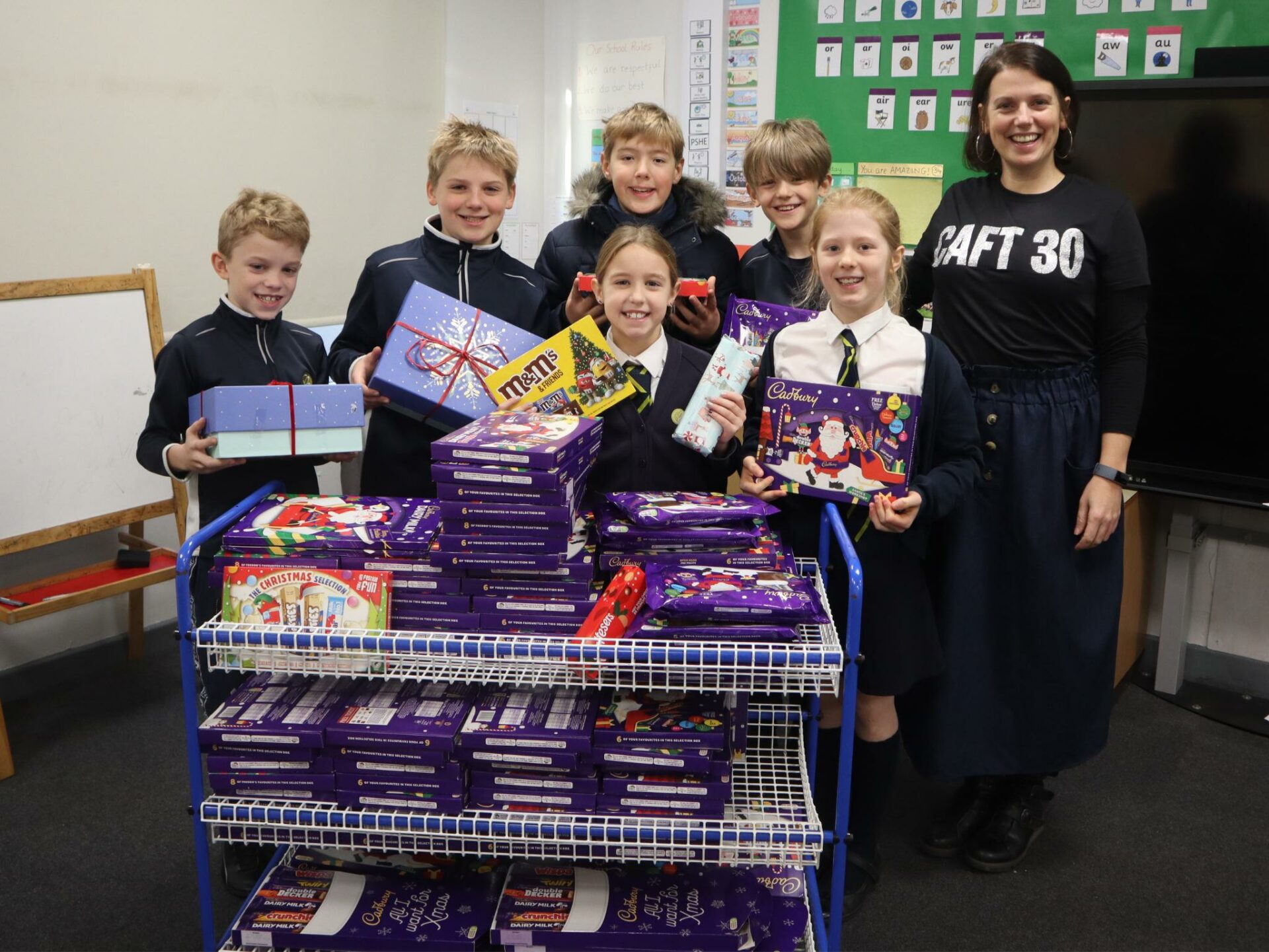 Pupils from the Treasury give the donated selection boxes to Hannah from CAFT