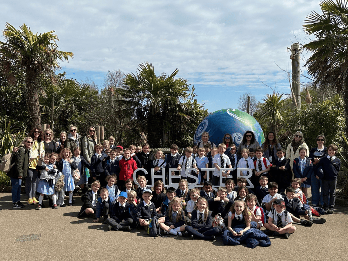 Year 3 pupils from Gorsey Bank stand in front of the welcome sign at Chester Zoo.