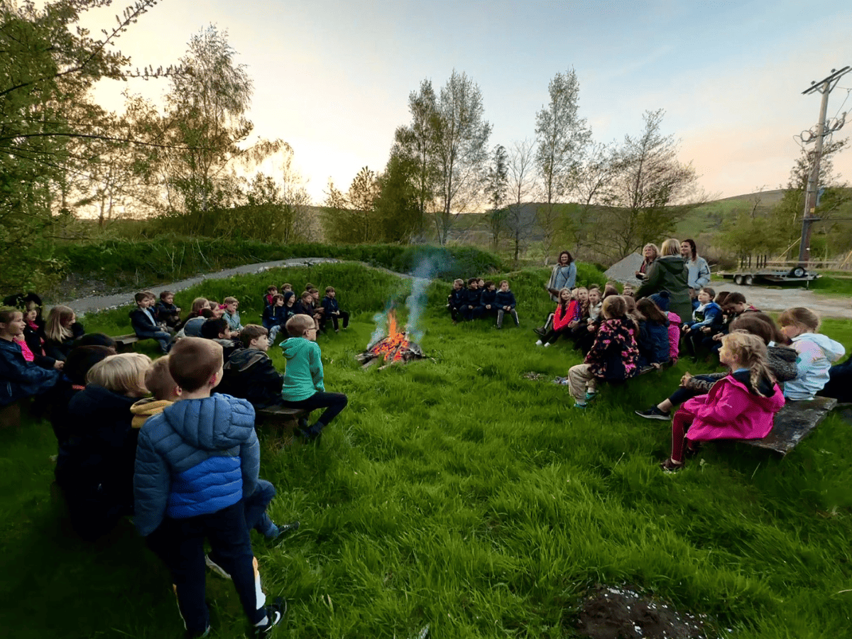 Gorsey Bank Year 3 pupils sit around a camp fire during their residential trip
