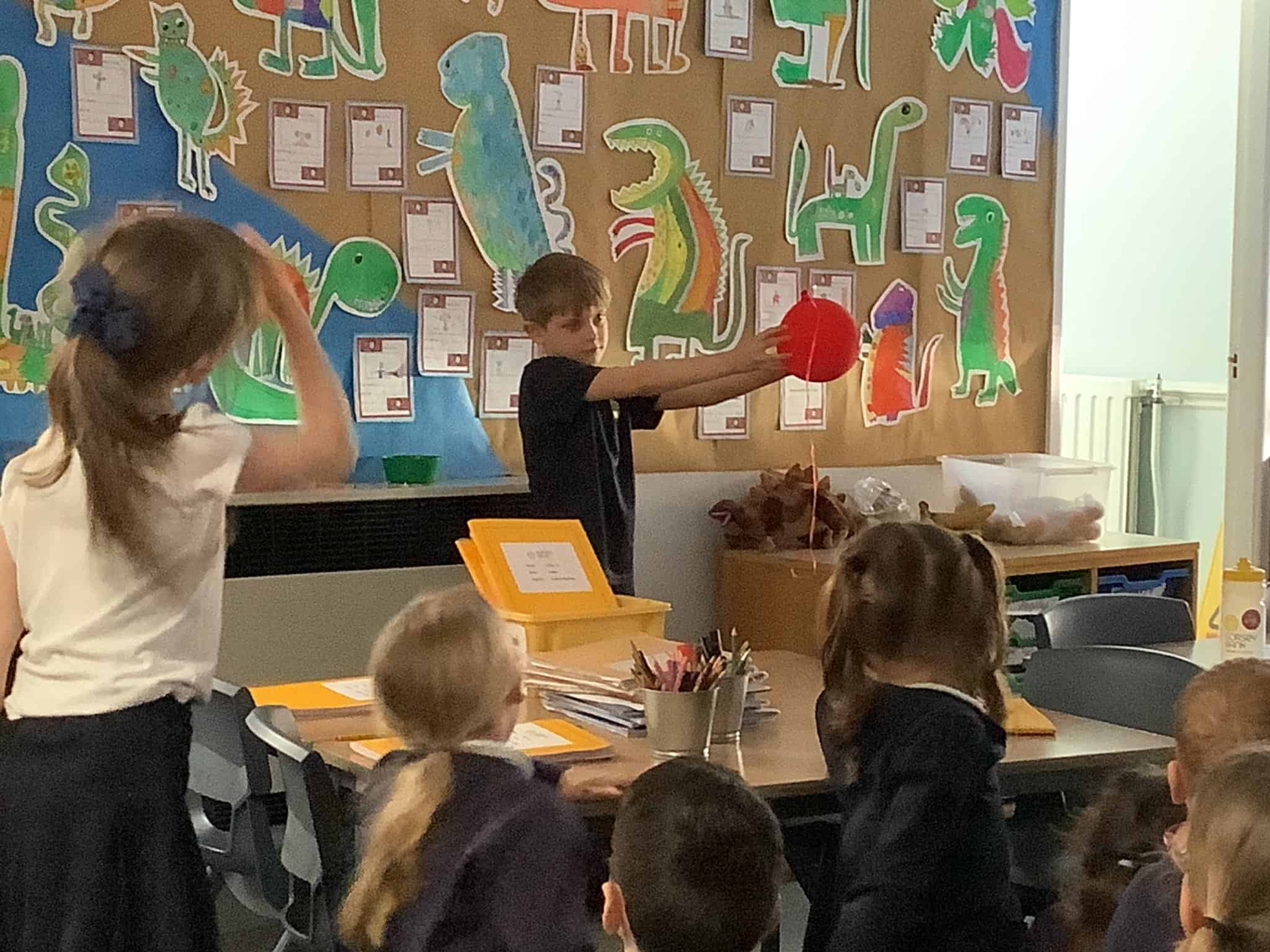 A pupil from Gorsey Bank holds a balloon as part of an experiment with lasers